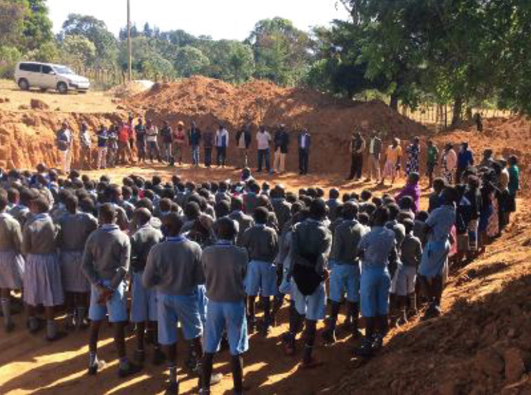 Photo of Kenyans standing around school foundation